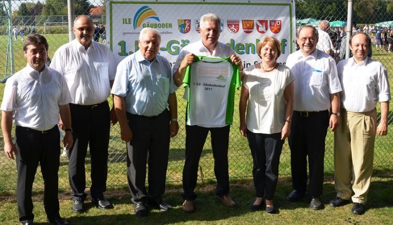 Gruppenfoto mit Trikot in der Hand